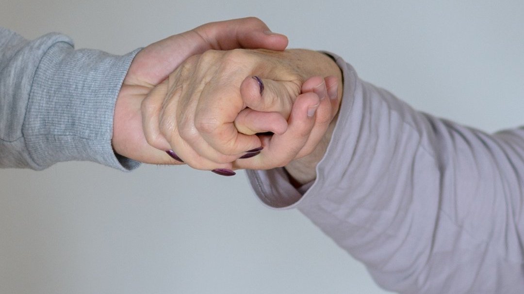 Imagem de uma mão segurando a mão de outra pessoa