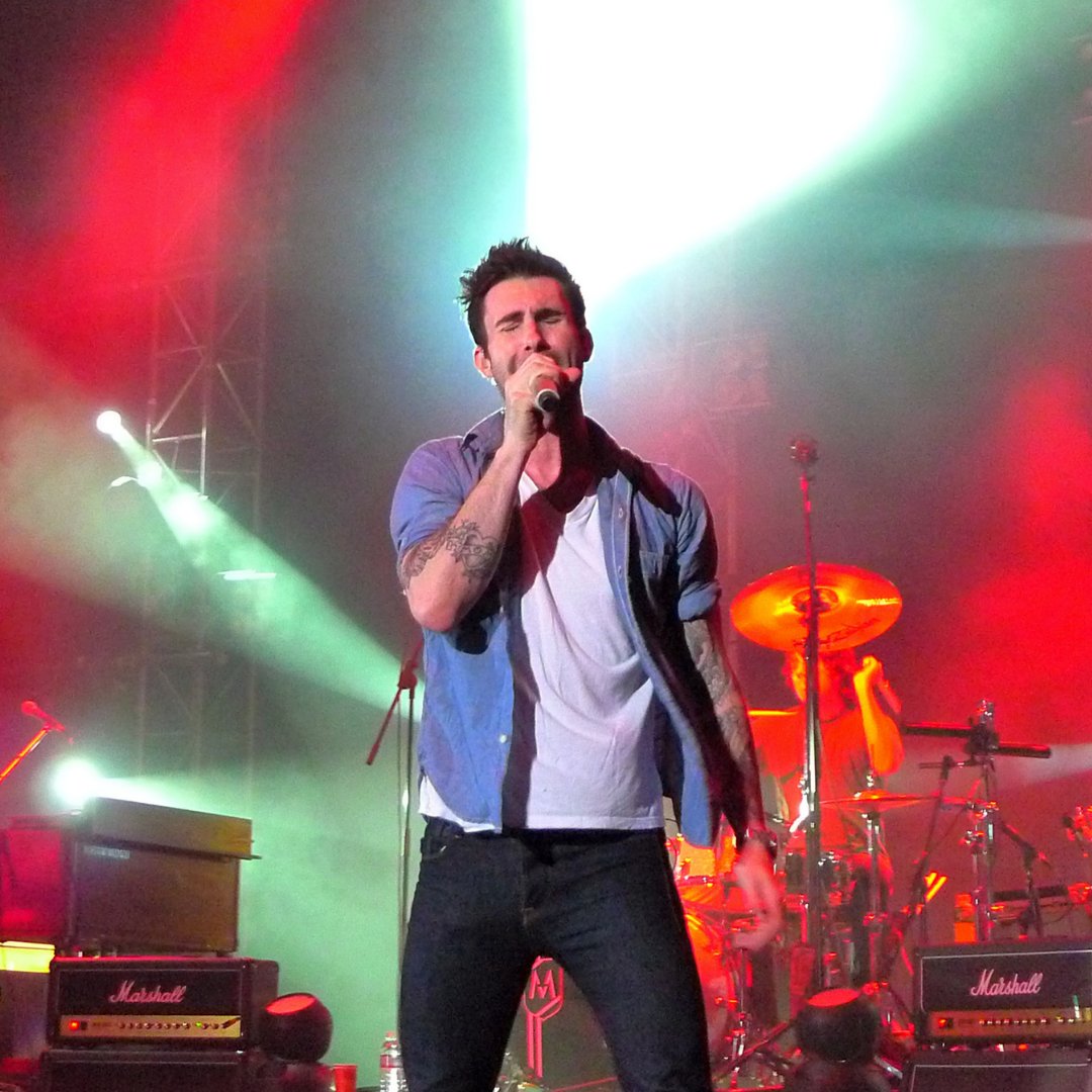 Imagem do cantor Adam Levine cantando em um show