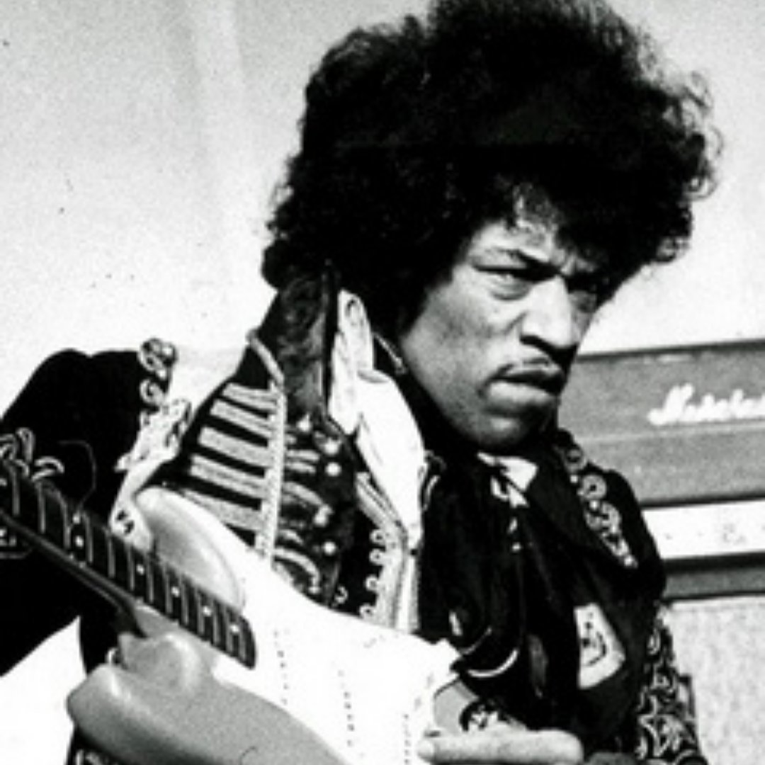 Imagem do cantor Jimi Hendrix em um palco tocando guitarra