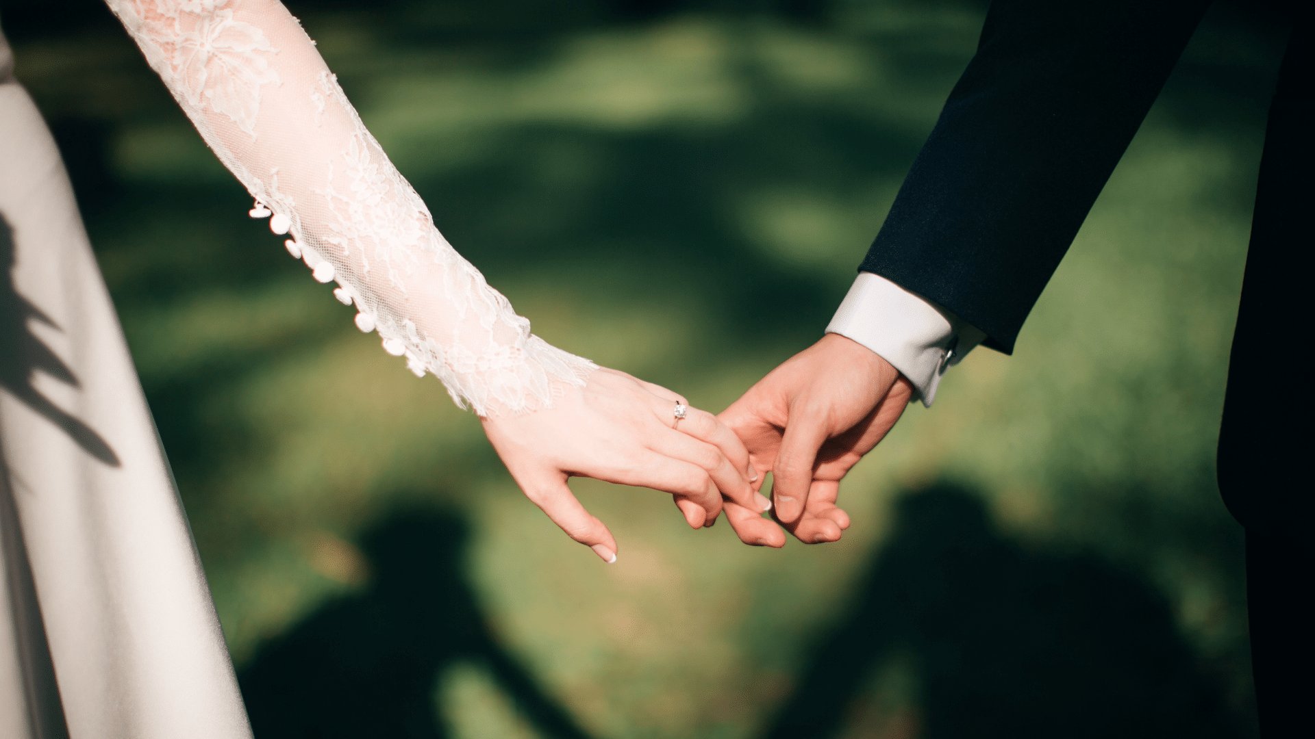 Noiva e noivo segurando um a mão do outro