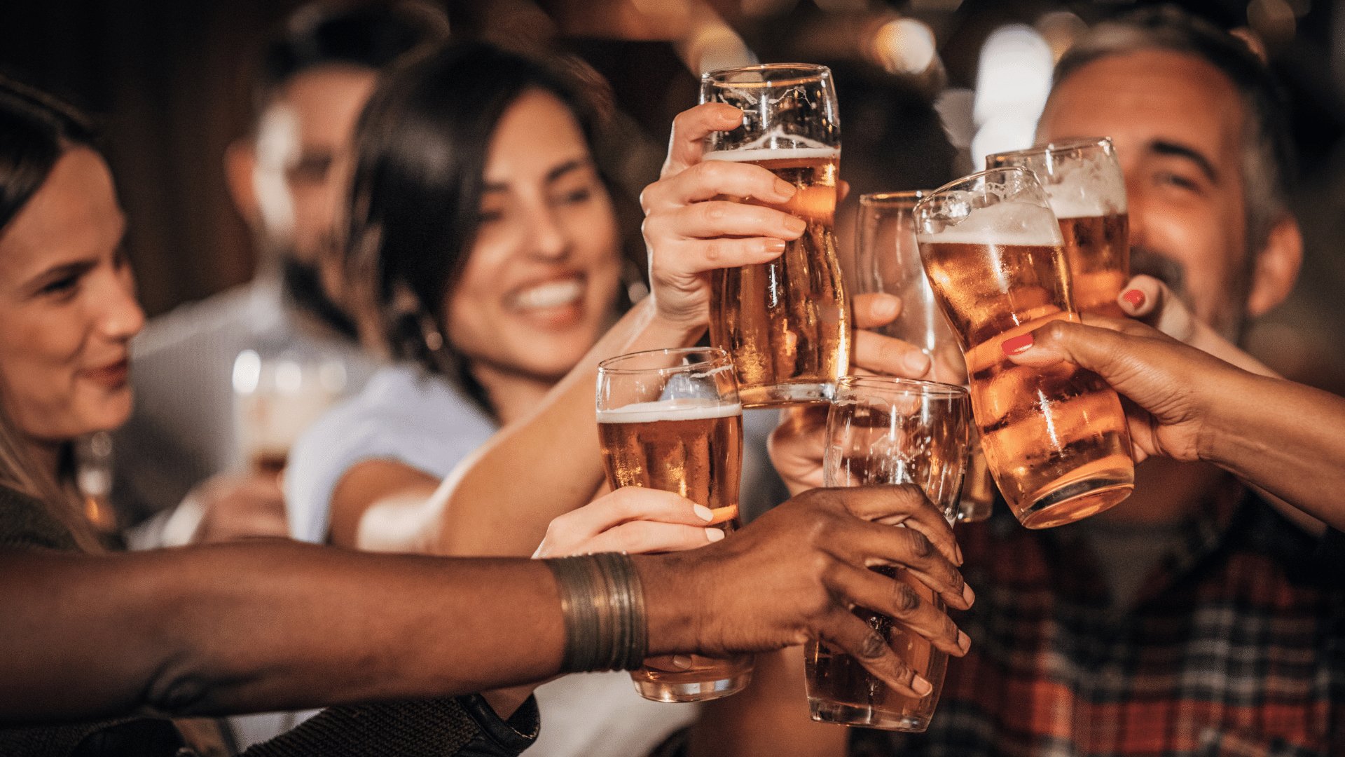 Grupo de amigos brindando com diversos copos repletos de cerveja