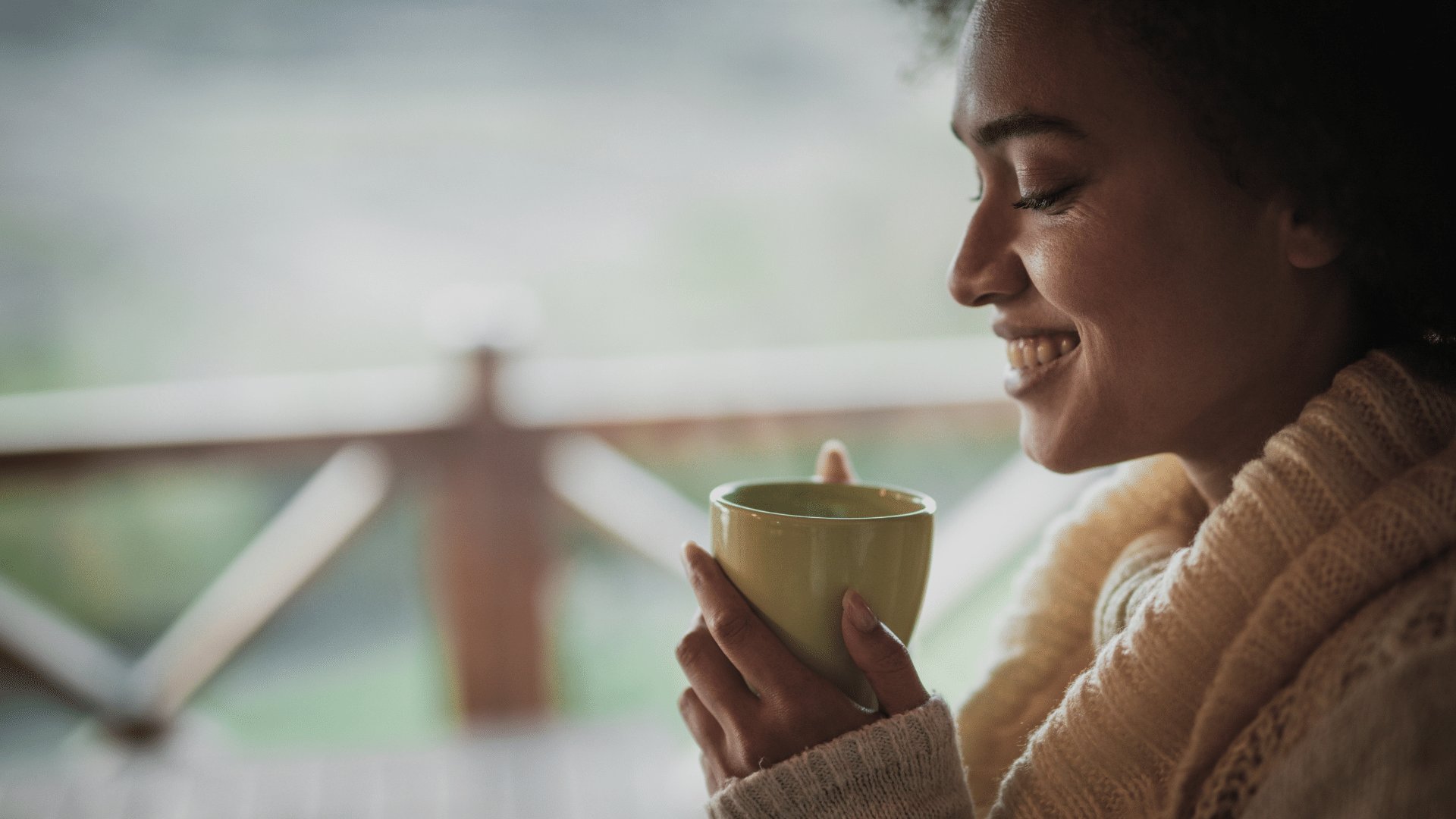 Mulher segurando uma caneca de café e sorrindo
