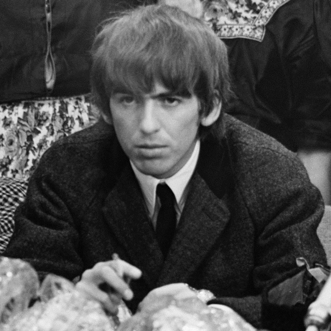 Imagem em preto e branco do guitarrista George Harrison, da banda Beatles