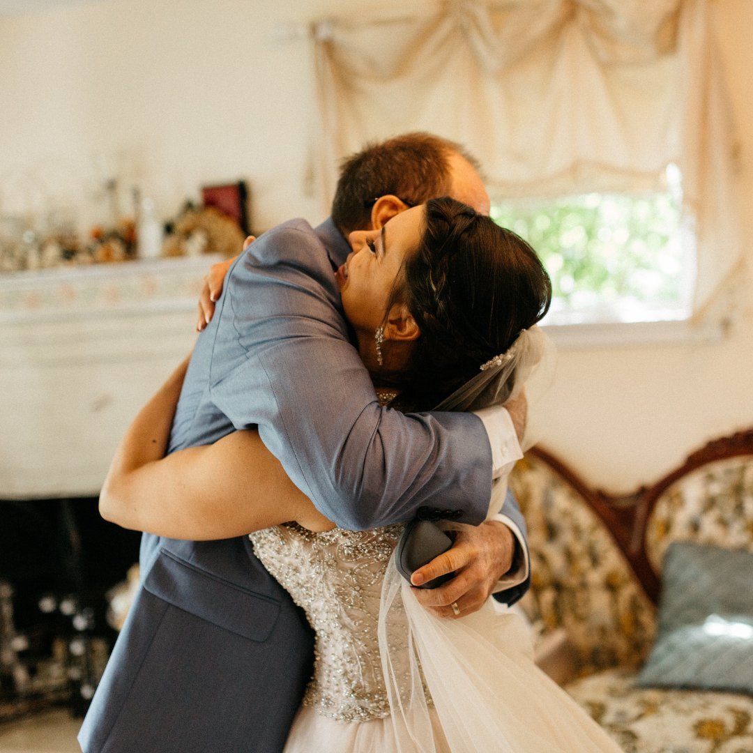 Homem e mulher vestida de noiva abraçados