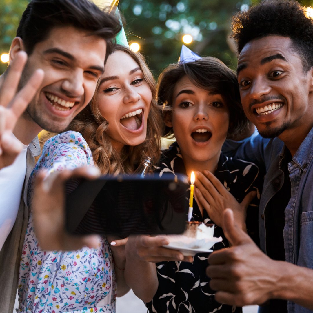 Amigos tirando uma selfie com um bolo