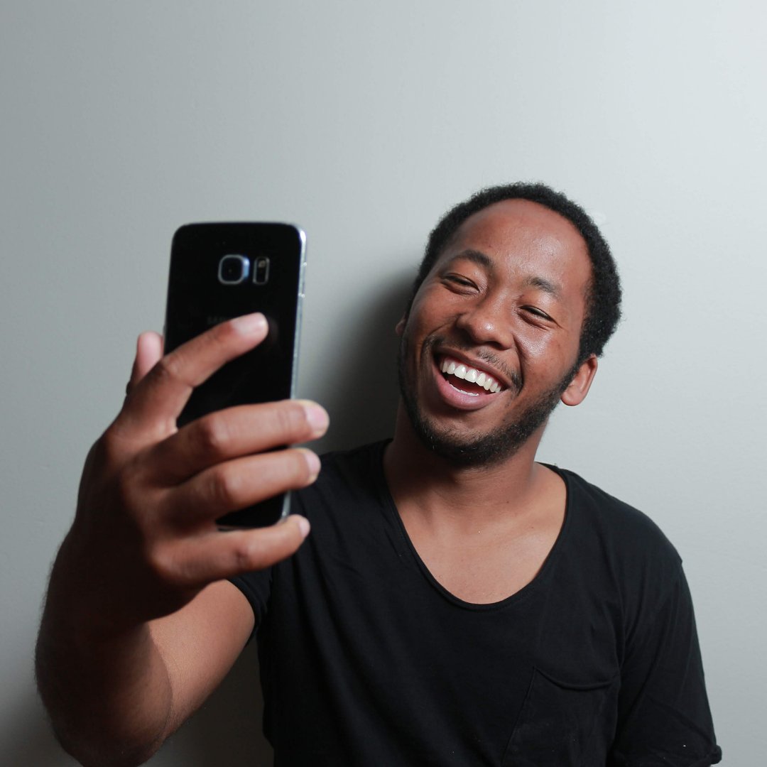 Homem sorrindo para o celular