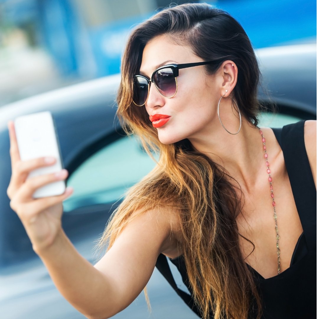 Mulher de óculos de sol tirando selfie