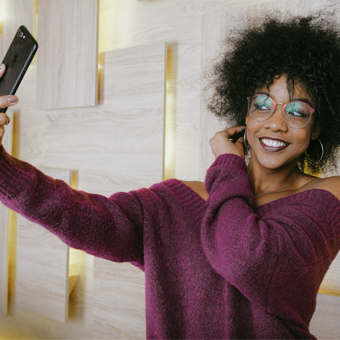Mulher sorrindo tirando uma selfie