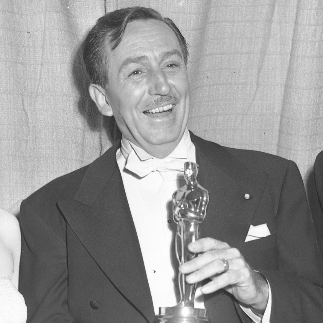 Imagem do empresário e cineasta Walt Disney segurando a estatueta do Oscar