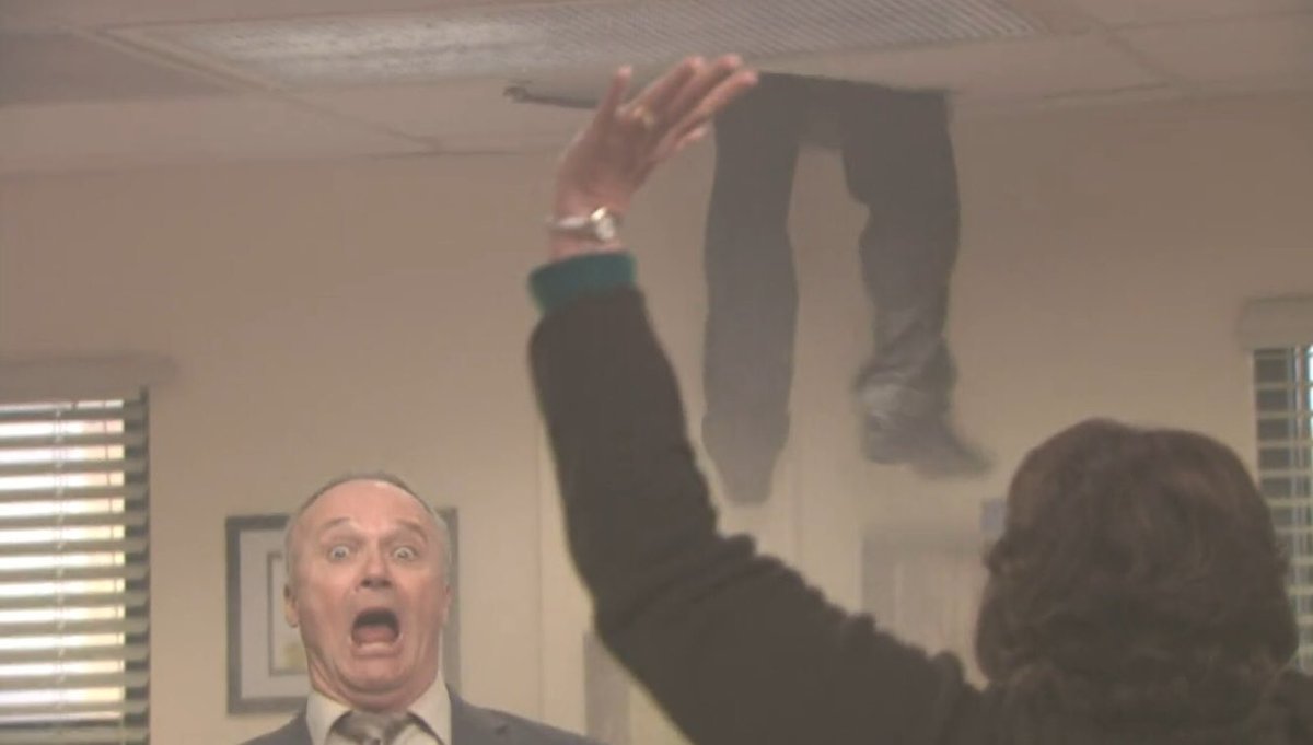 Oscar tentando sair pelo teto enquanto durante a simulação de incêndio no escritório.