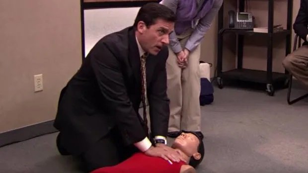 Michael fazendo massagem cardíaca no boneco durante treinamento de primeiros socorros.