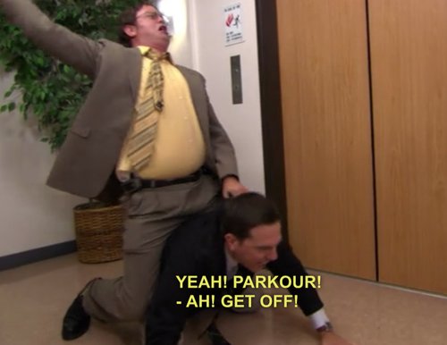 Andy agachado no chão do escritório com Dwight montado em suas costas gritando parkour.