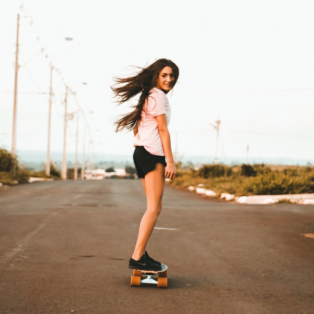 Menina andando de skate na rua