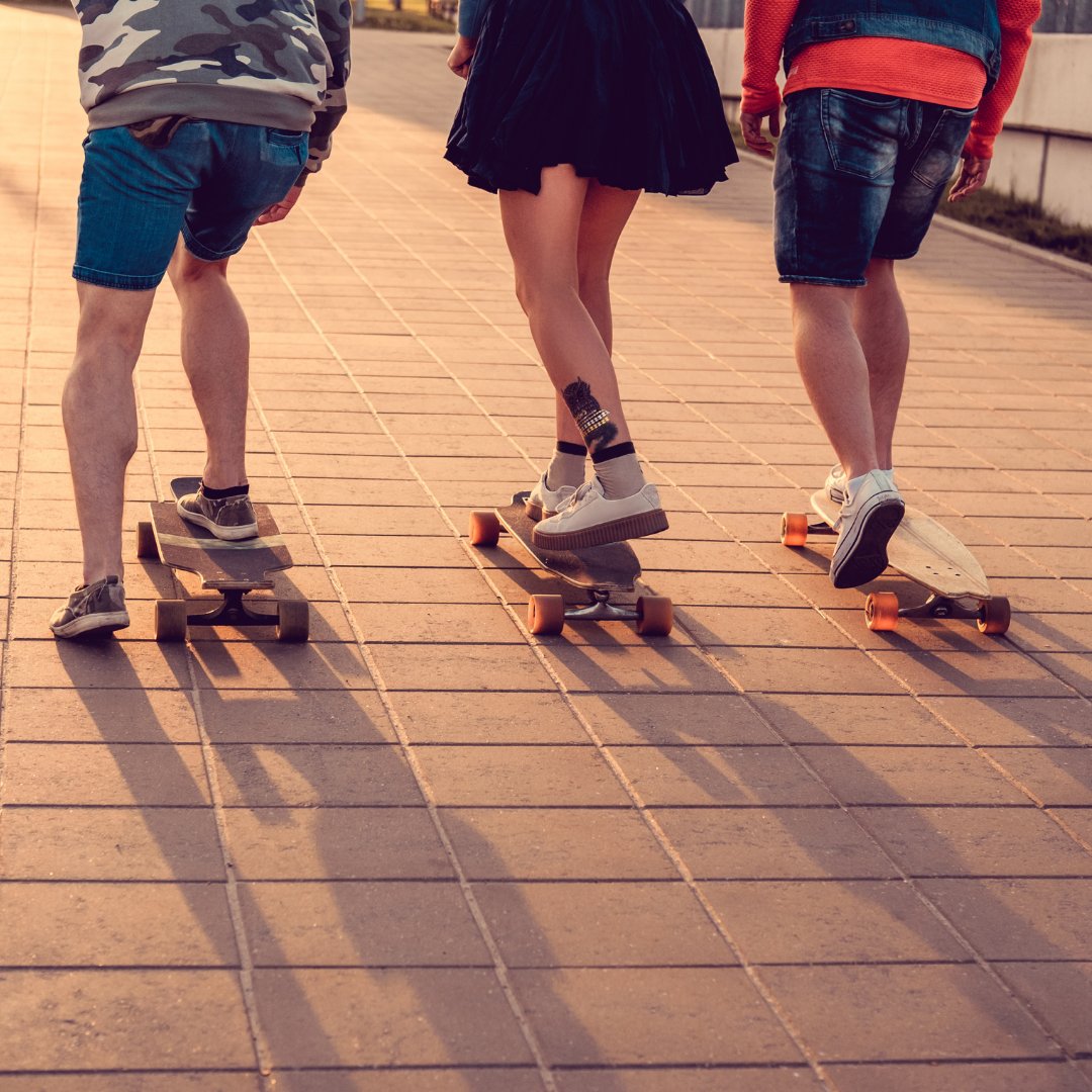 Três pessoas andando de skate