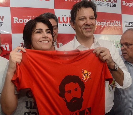 Fernando Haddad e Manuela segurando uma camiseta com o rosto do Lula.