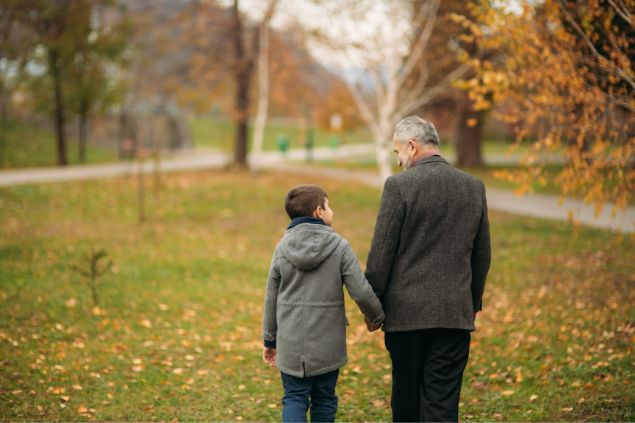 Avô andando pelo parque com seu neto pequeno