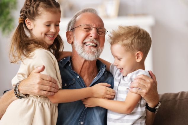 Avô abraçando seus netos na sala de estar