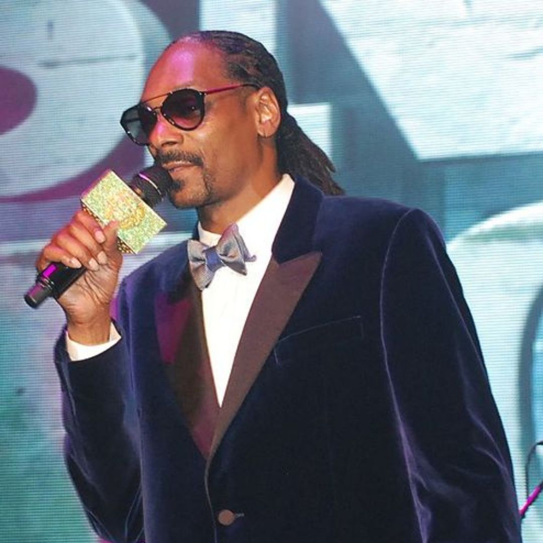 Snoop Dogg em premiação, segurando um microfone