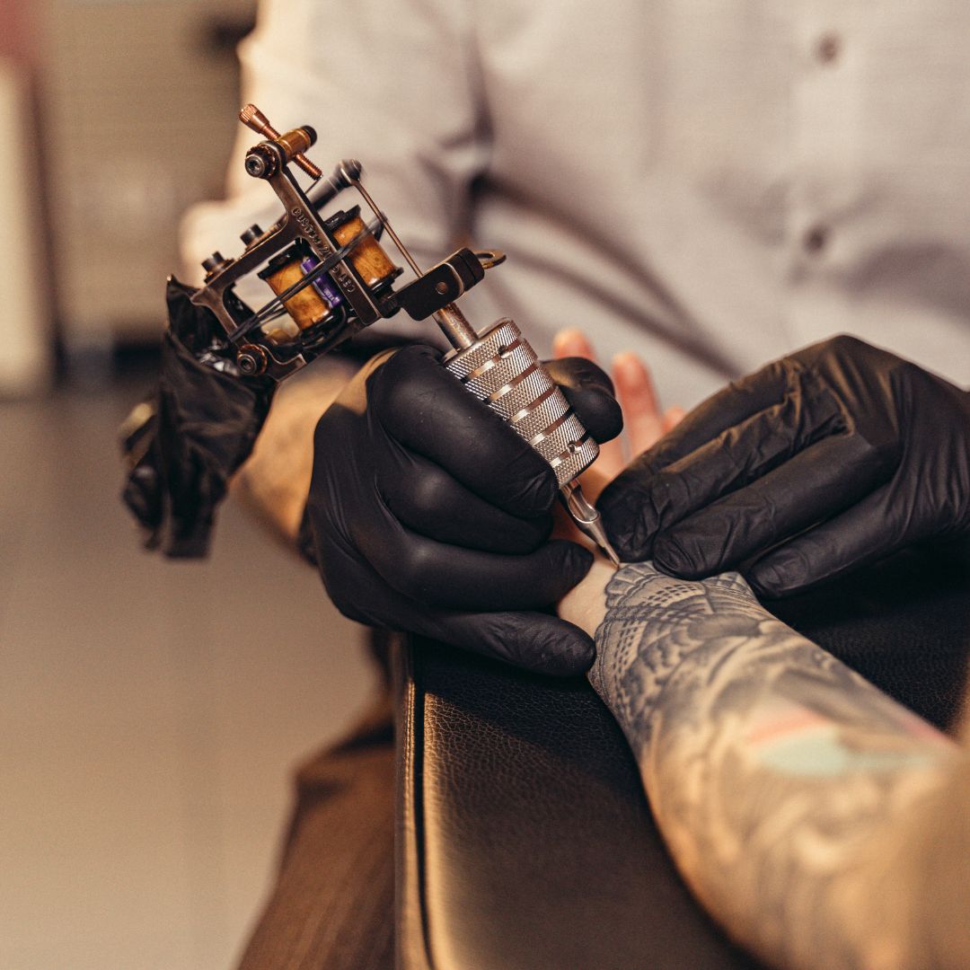 Pessoa fazendo tatuagem no braço.