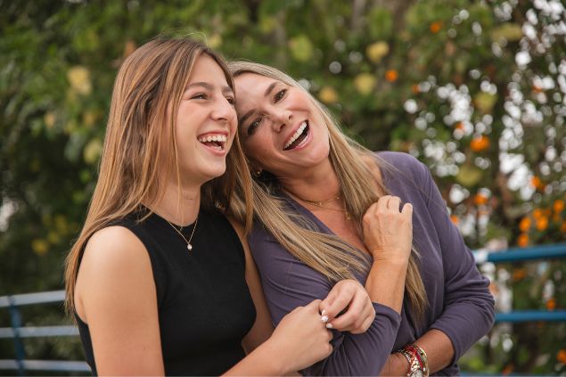 Duas mulheres loiras se abraçando e rindo