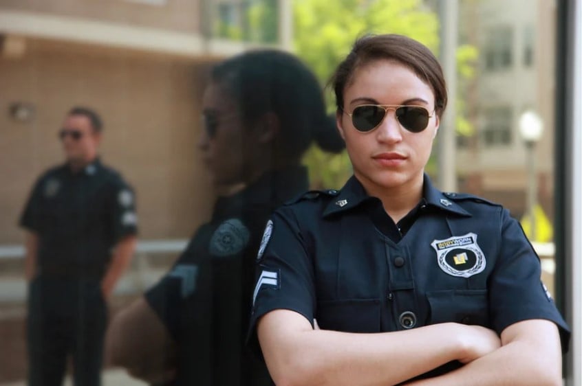 Mulher policial com óculos escuros olhando para câmera