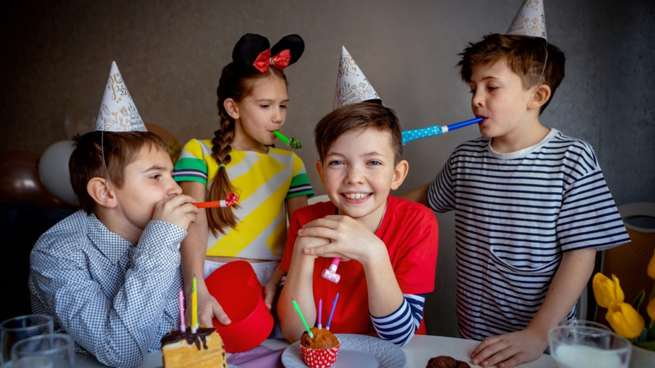 Crianças comemorando aniversário com artefatos de festa