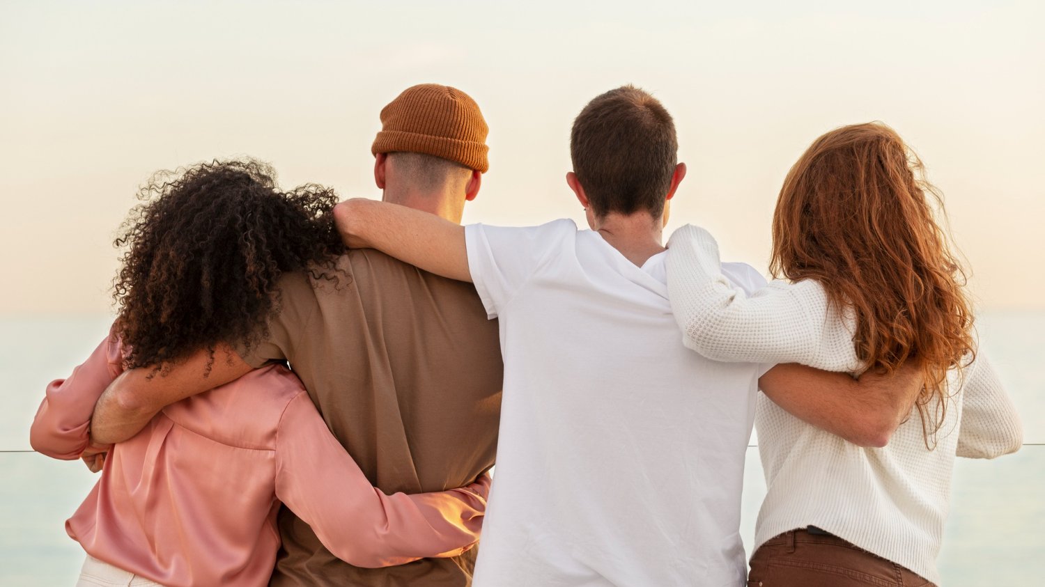 Amigos de diferentes etnias abraçados de costas