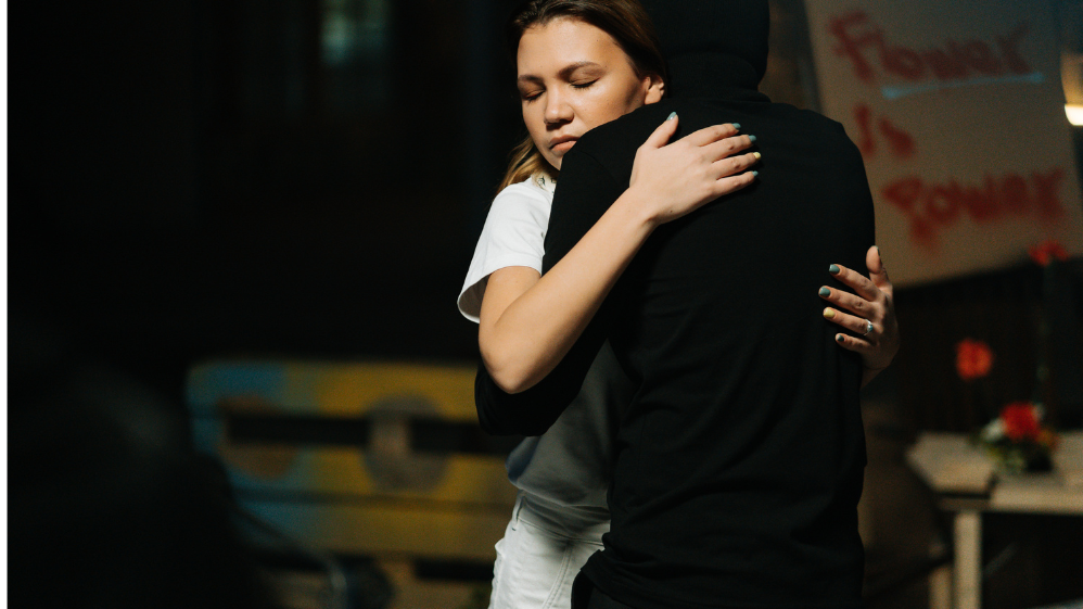 cottonbro / Pexels Homem e mulher se abraçando. O homem está de costas e a mulher, de olhos fechados