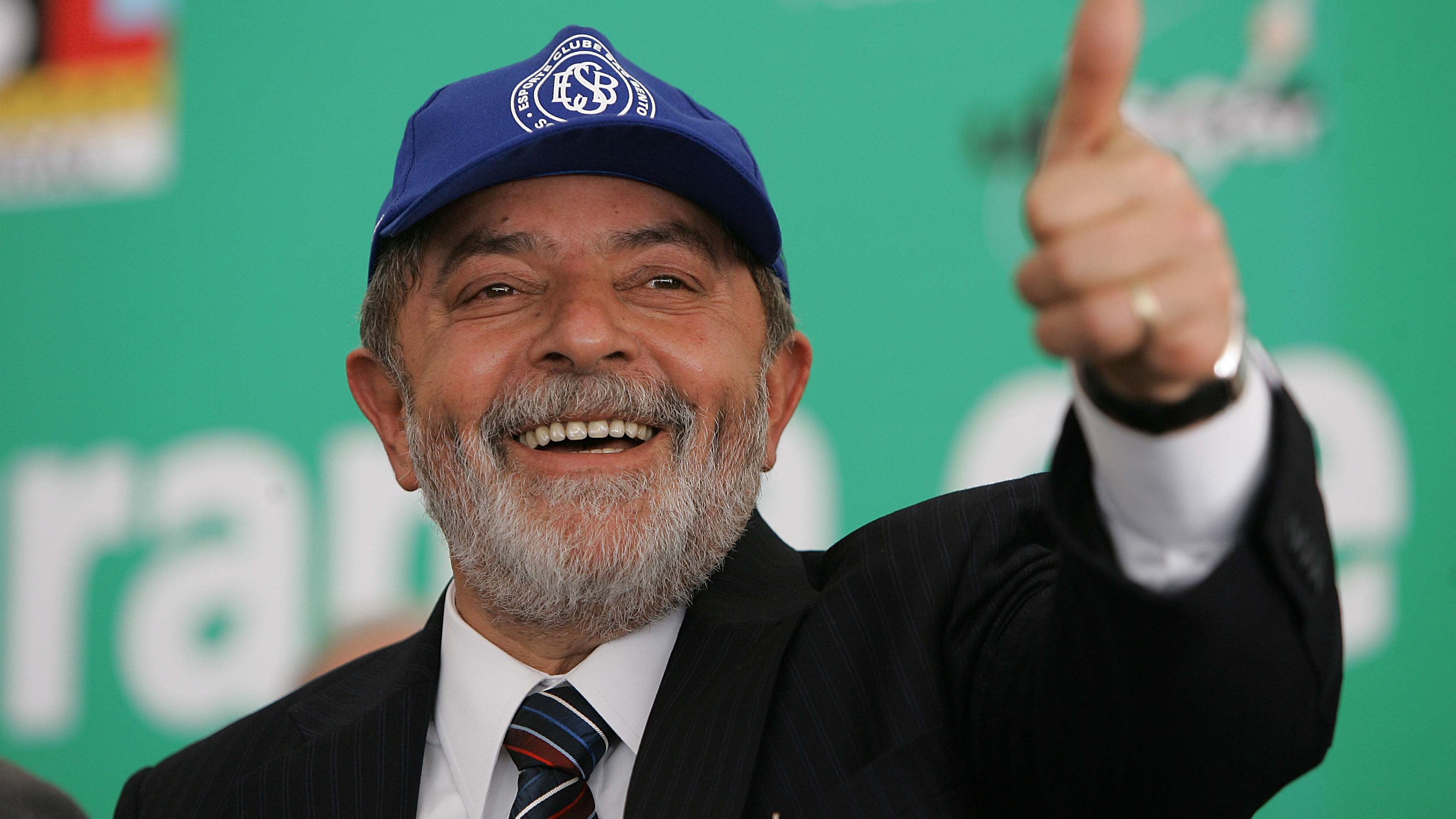 Luiz Inácio Lula da Silva de boné fazendo sinal positivo com a mão