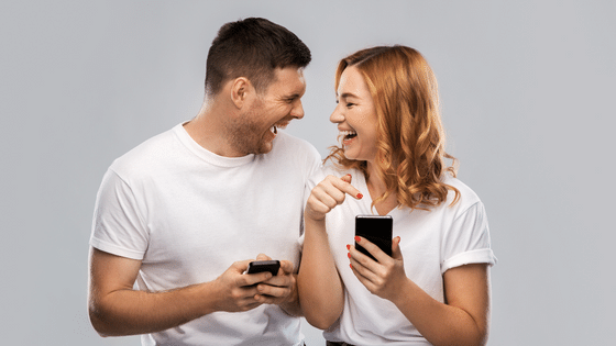 Casal rindo enquanto olha o celular