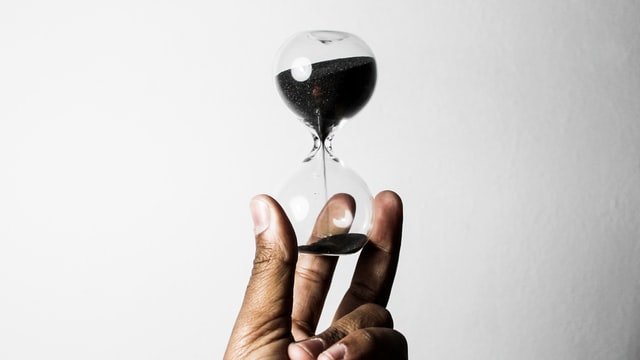 unsplash / Who’s Denilo ? Uma mão segurando uma ampulheta