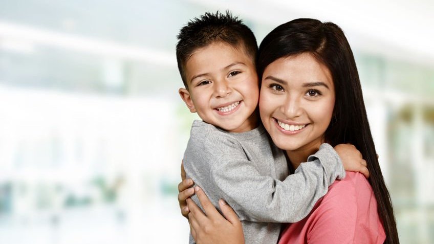 Mãe e filho sorrindo e se abraçando