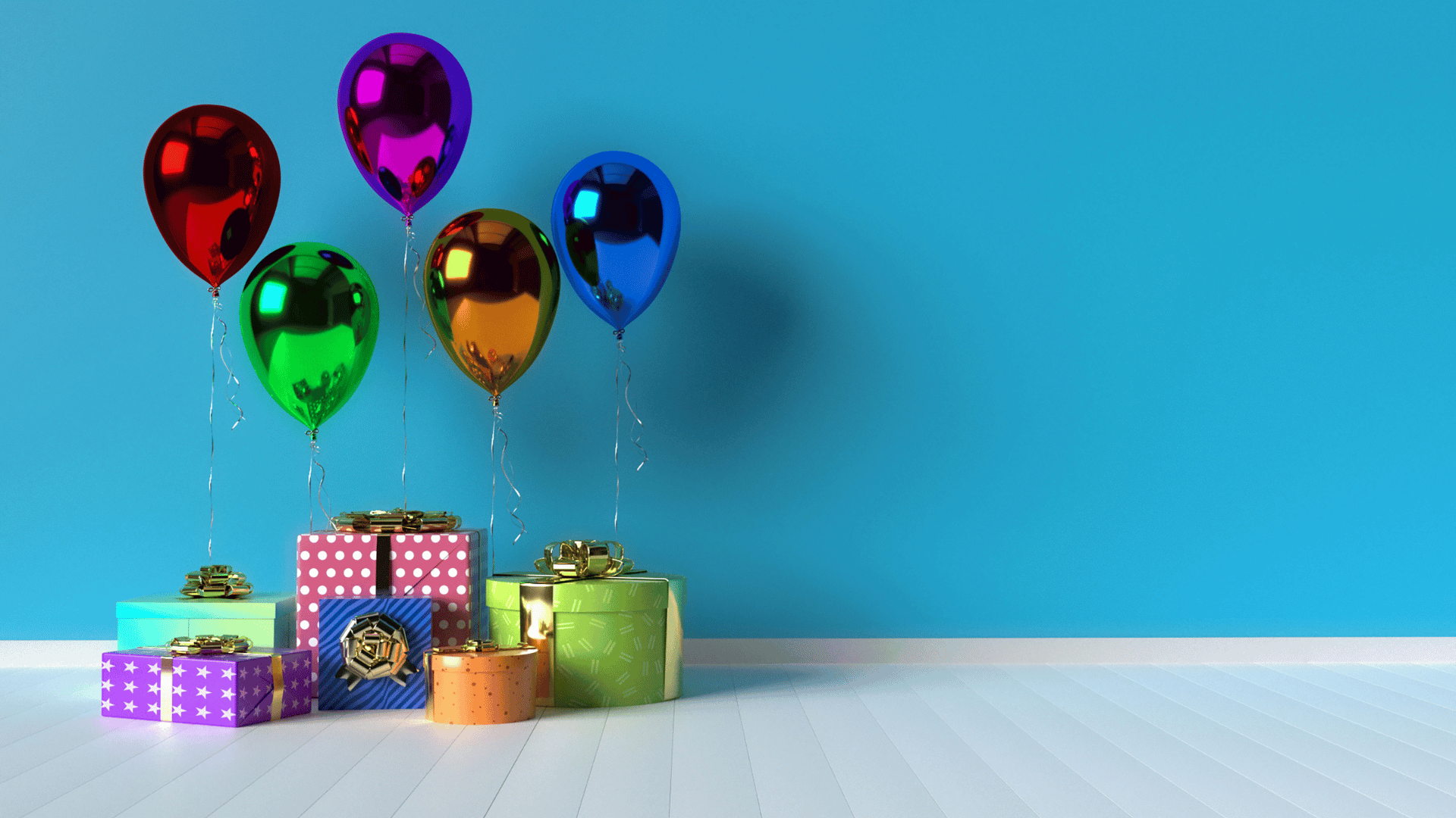 Imagem com uma parede de fundo azul. No chão várias caixas de presentes coloridas com formatos variados e também balões de várias cores.