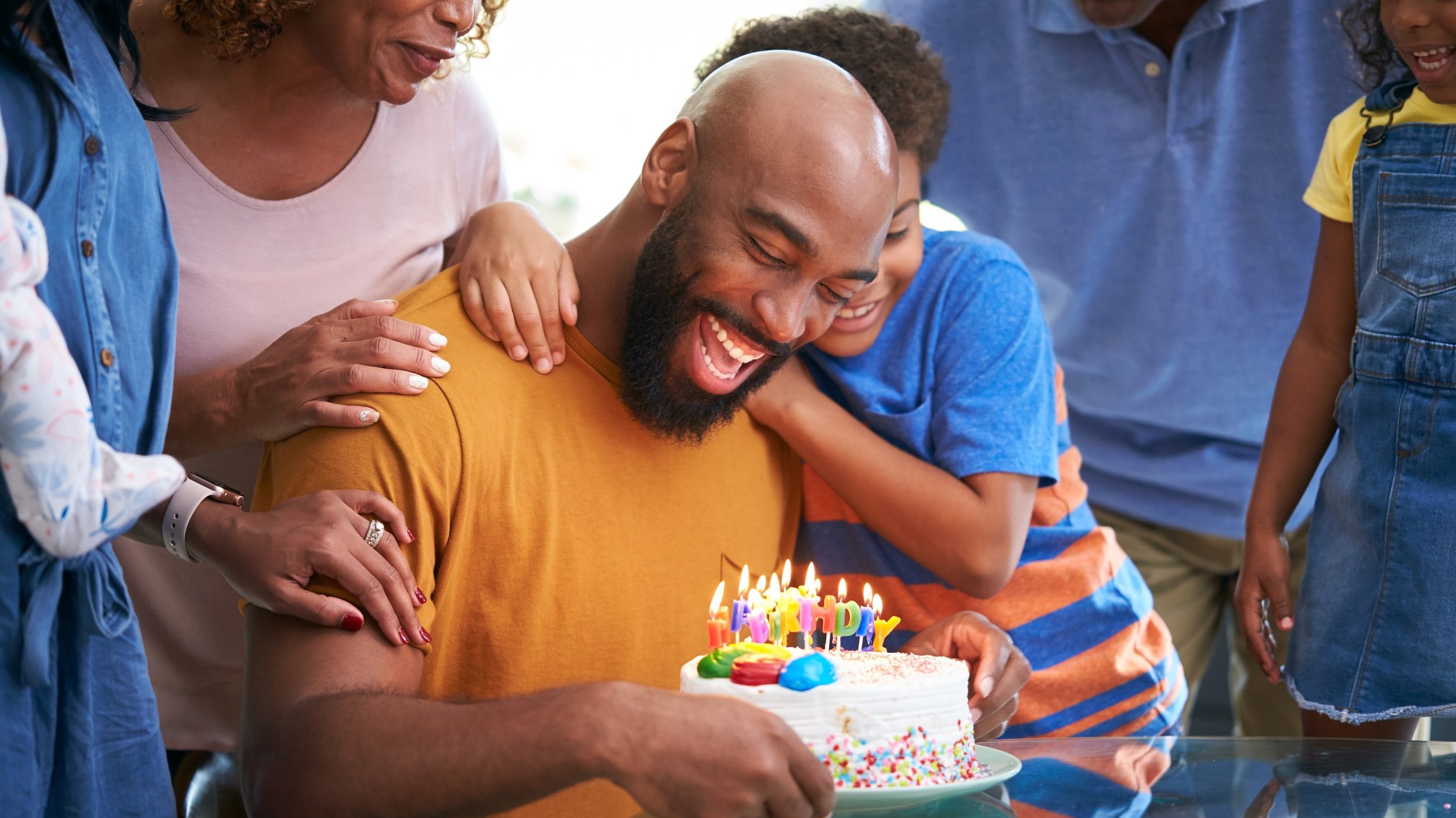 Homem segurando bolo de aniversário e rindo