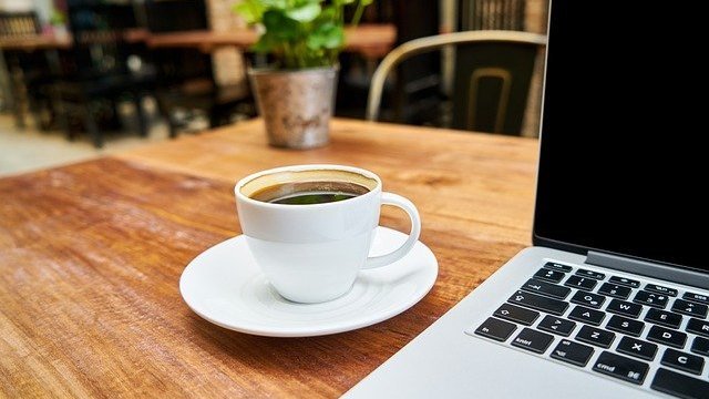 Xícara de café ao lado de notebook