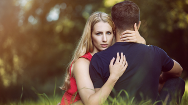 panajiotis / Pixabay Mulher abraçando um homem de costas, enquanto olha para câmera