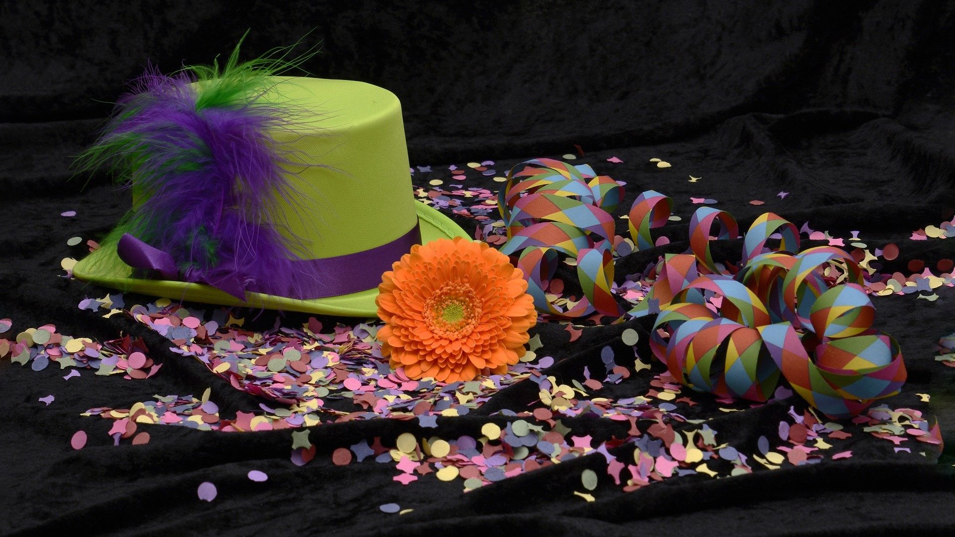 Chapéu, confetes e flor um ao lado do outro representando o carnaval