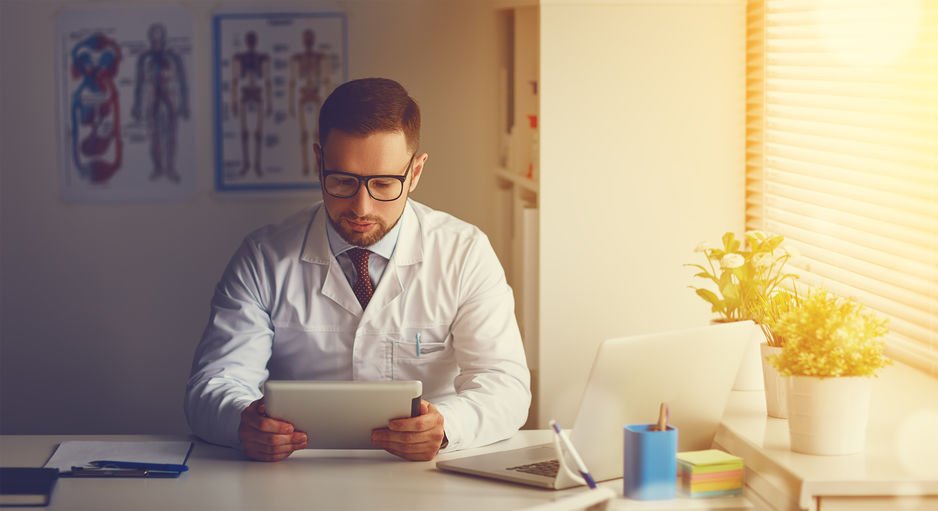 Médico com computador tablet em seu escritório