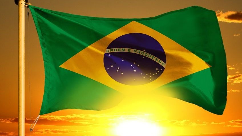 Bandeira do Brasil com sol refletindo ao fundo