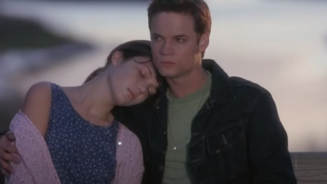 Imagem de Jamie e Landon do filme Um Amor para Recordar, sentados e abraçados