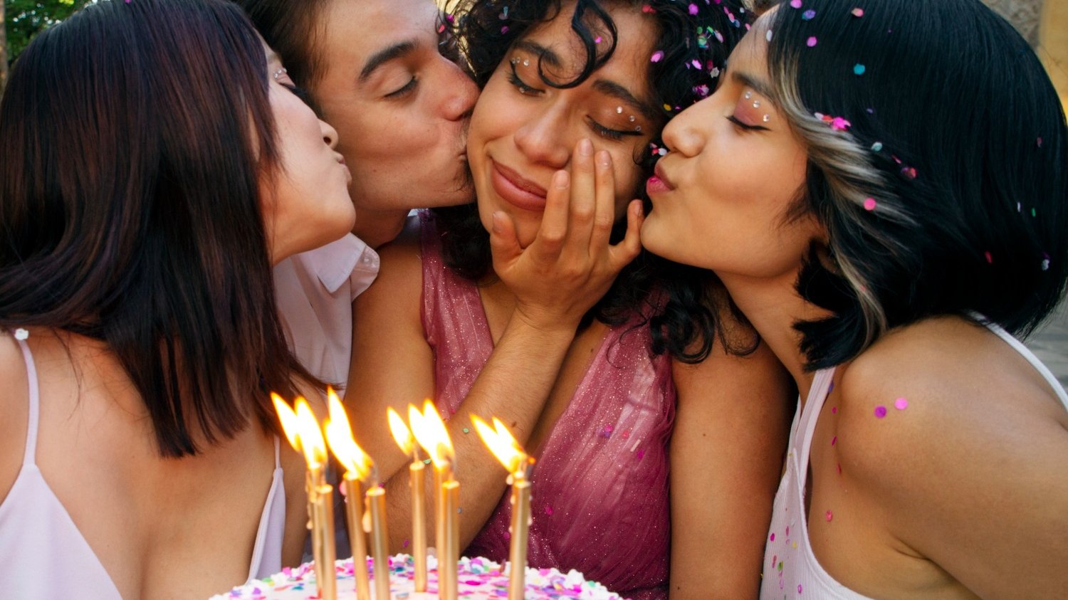 Quatro meninas de diferentes etnias segurando um bolo de aniversário felizes