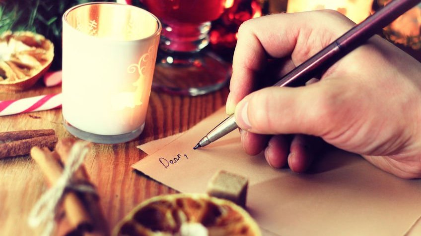 Uma pessoa escrevendo uma carta de amor para o Natal