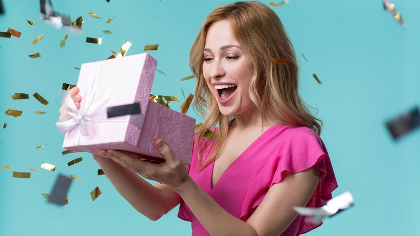 Mulher abrindo caixa de presente sorrindo