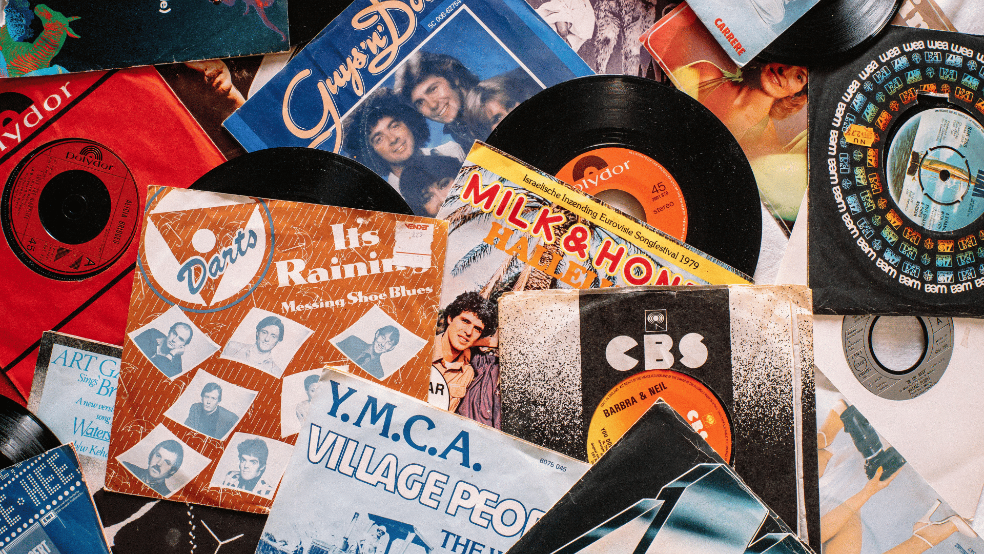 Cenário de vários discos de vinil retrôs espalhados em uma mesa.