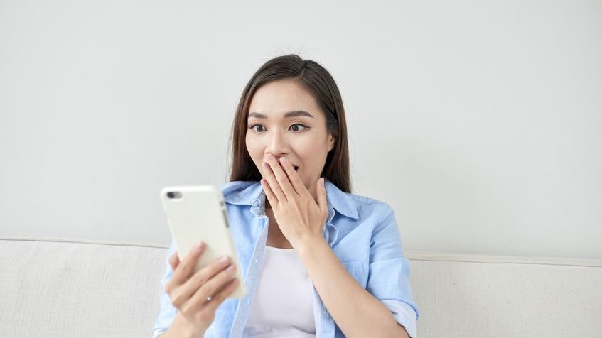123rf / marctran Mulher surpresa olhando celular