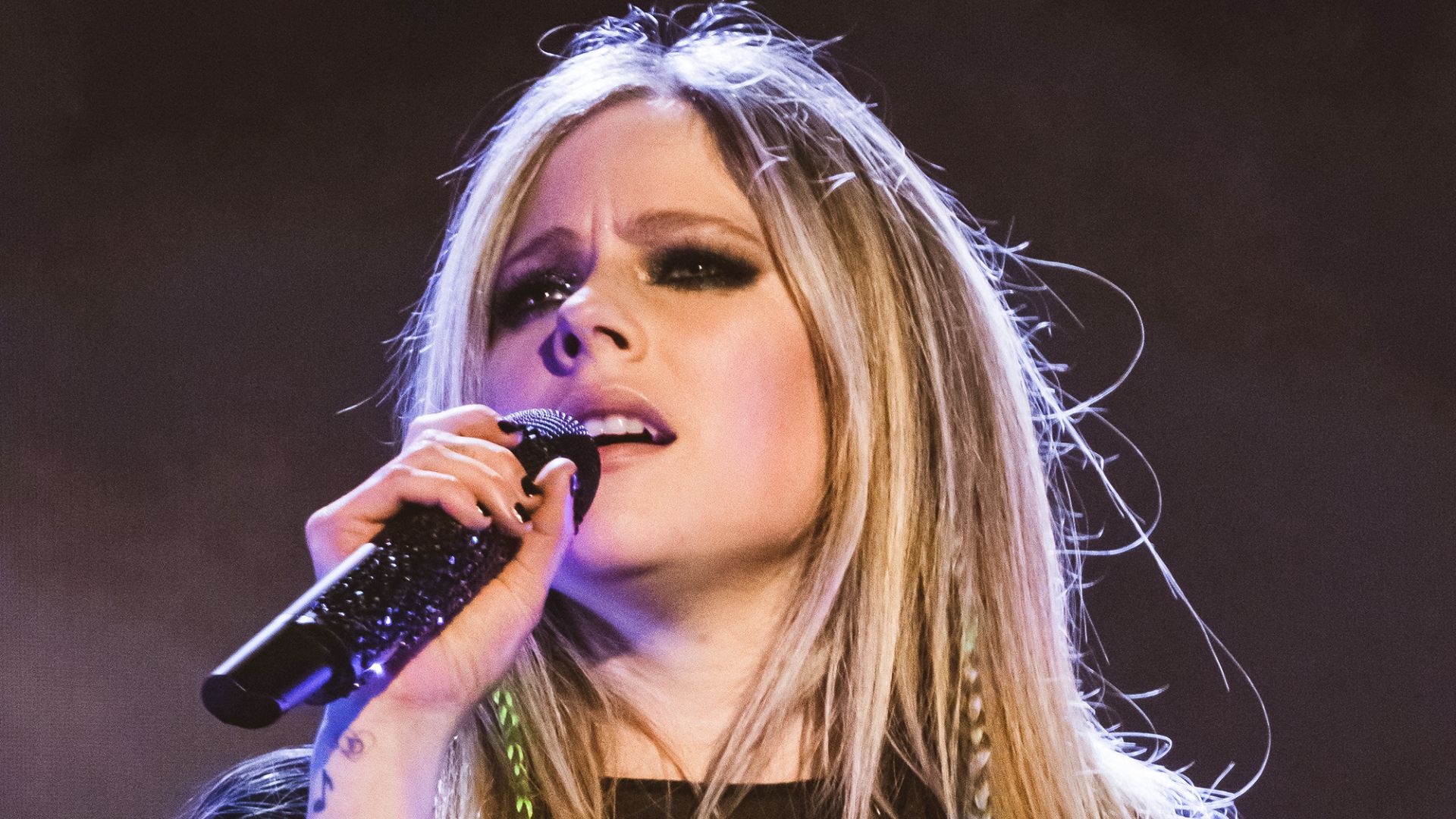 Imagem da cantora Avril Lavigne cantando