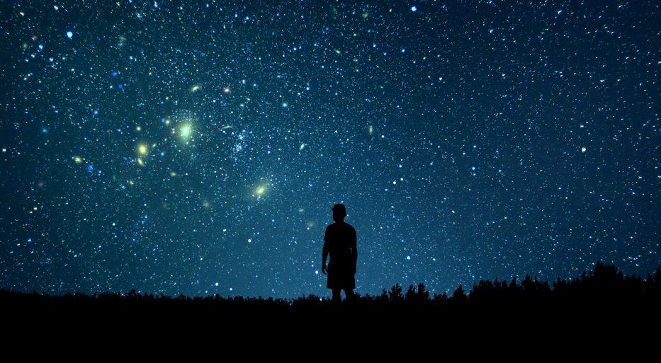 Imagem da silhueta de uma pessoa olhando o céu estrelado