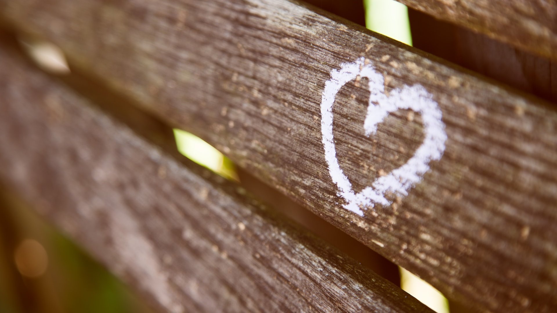 Coração desenhado em giz, em um banco de madeira.
