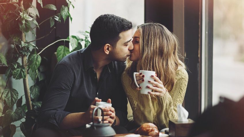 Homem e mulher se beijando apaixonadamente.