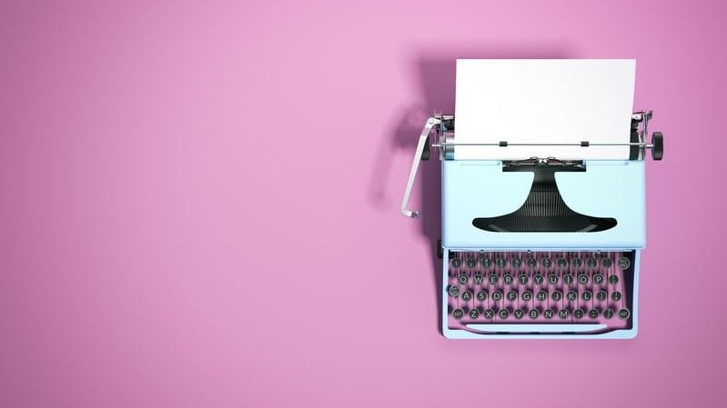 Máquina de escrever vista de cima em fundo cor de rosa